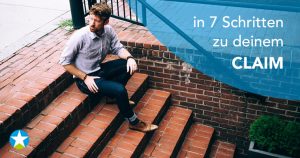 Junger Mann mit Bart und rotblonden Haaren sitzt auf einem steinernden Treppenabgang und schaut nach über seine Schulter nach oben zur Straße.